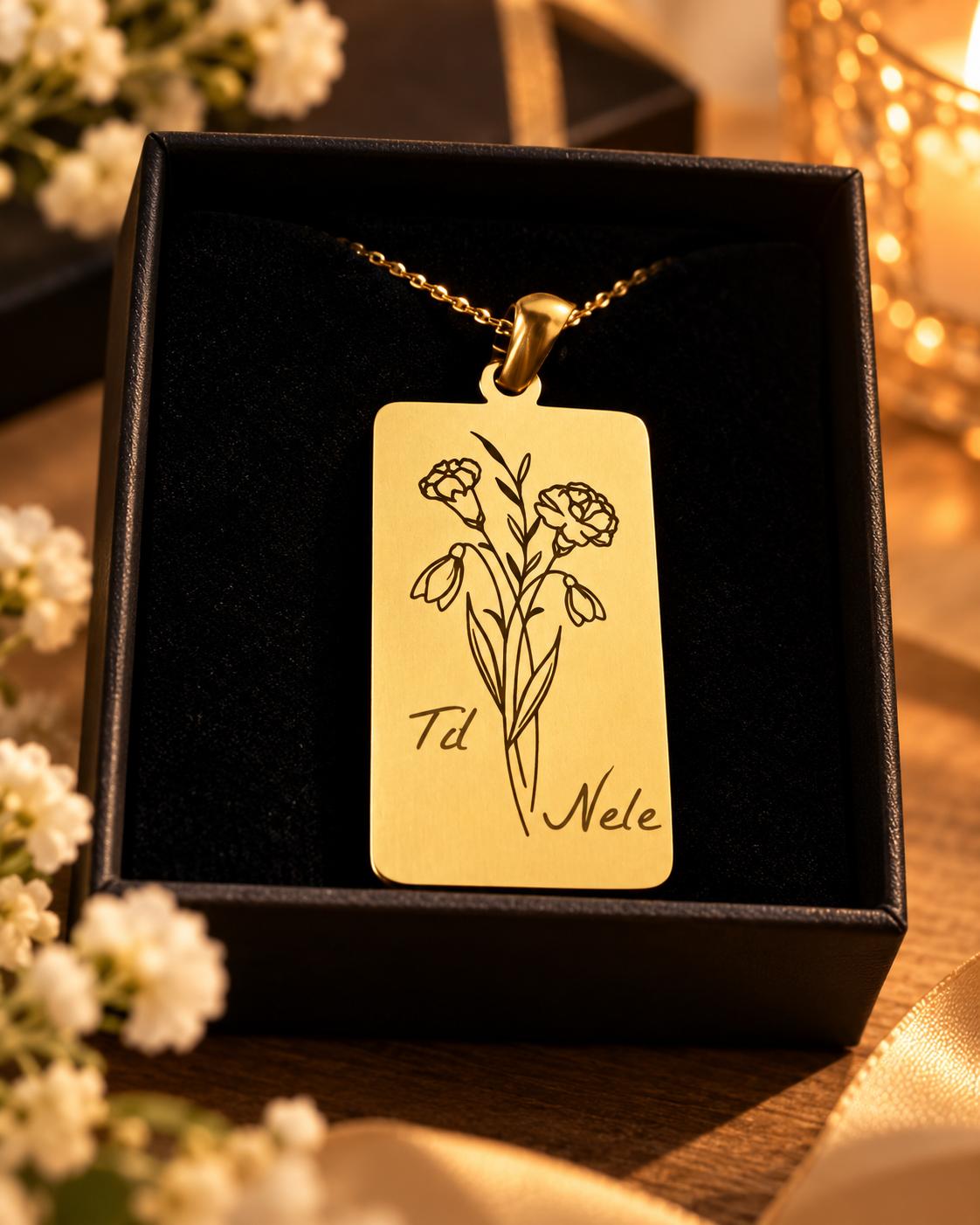 Goldfarbener Anhänger mit Blumenmotiv und Namen in Geschenkbox